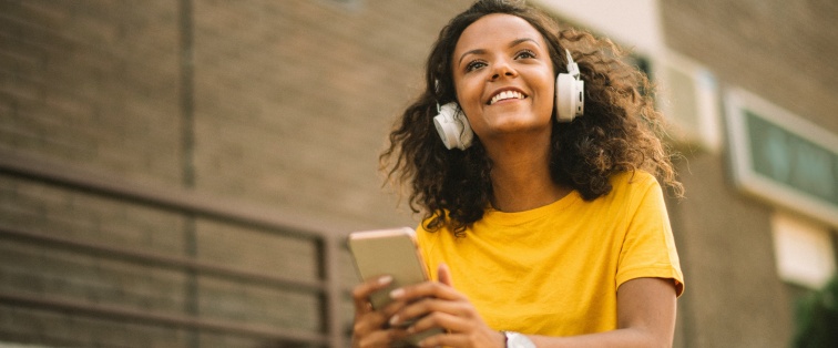 teenage girl wearing headphones looking at phone